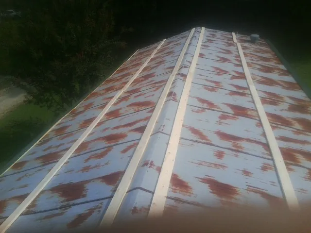 Rusted metal roof panels with new wood purlins before replacement — Storm Damage Roof Repair in Richford by Roofing Brothers