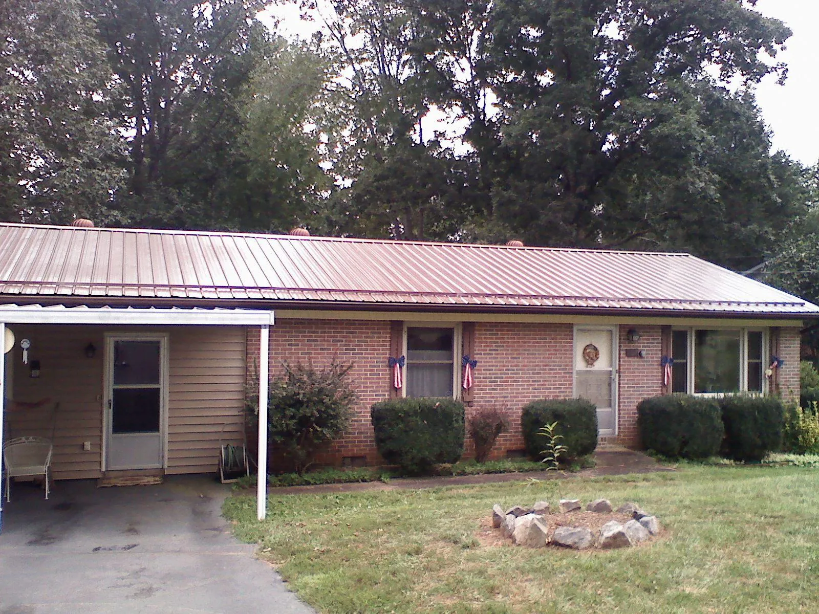Bronze metal roof and carport on a brick ranch home — Roof Repair work by our crew in Richford